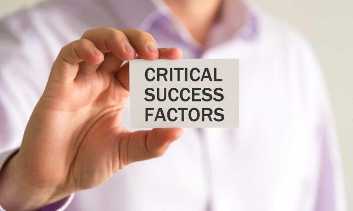 Persona con tarjeta en la mano letrero critical success factors