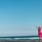 Estrategia del océano azul | Domina esta teoría y nada sin «tiburones» Mujer vestida de rojo frente al mar
