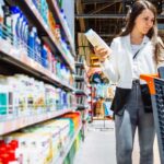 Sensibilidad al precio | ¿Ya sabes determinar cuánto pagarían tus clientes? Mujer comprando en el mercado decide entre dos frascos