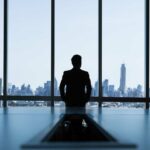 Internacionalización de una empresa | ¡A conquistar nuevos mercados! hombre de pie mirando hacia afuera por un ventanal de cristal