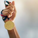 Personas exitosas | Descubre realmente qué hay detrás de la fachada mano sosteniendo medalla de oro