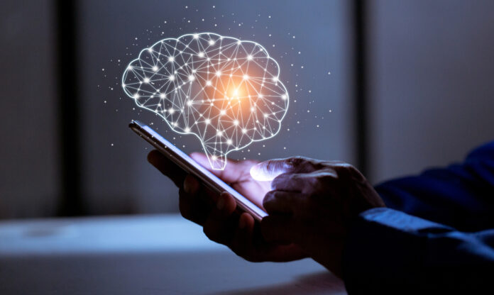Persona con un teléfono móvil en su mano y el holograma de un cerebro en referencia al neuromarketing