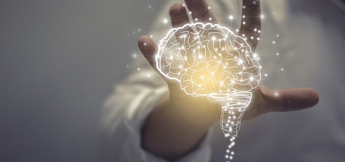 Persona tocando con su mano la imagen de un cerebro que simboliza las neuronas espejo en neuromarketing