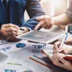 Cómo los profesionales de marketing lideran la transformación empresarial Miembros de un equipo de marketing utilizando un software de gestión empresarial