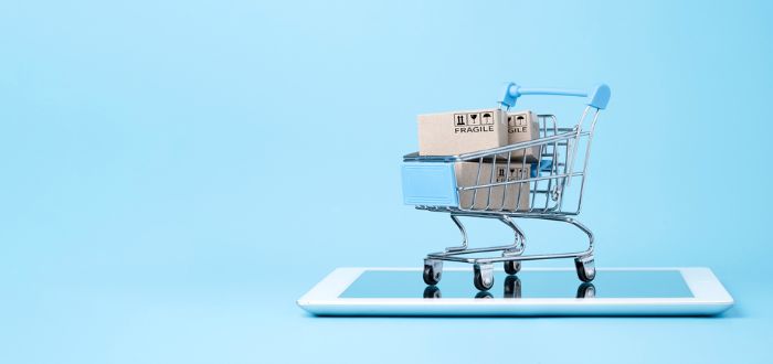 Carrito de compras sobre una tableta en representación de un e-commerce, uno de los canales de ventas en línea
