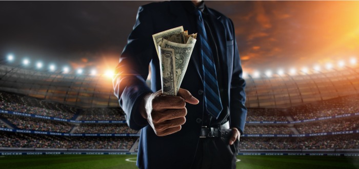 Hombre con dinero en un estadio de fútbol 