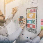 10 elementos de un plan de marketing | ¿Qué no puede faltar en tu guía? Dos hombres evaluando cuáles elementos de un plan de marketing van a utilizar.