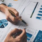 Cómo hacer una estrategia financiera | Tipos, beneficios, pasos y ejemplos Personas discutiendo cómo hacer una estrategia financiera