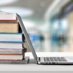 12 libros sobre marketing de afiliados | Aprende con los expertos Libros al lado de un ordenador portátil
