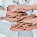 20 frases motivadoras de trabajo en equipo | Inspira a tus colaboradores Grupo de manos que simboliza frases de trabajo en equipo